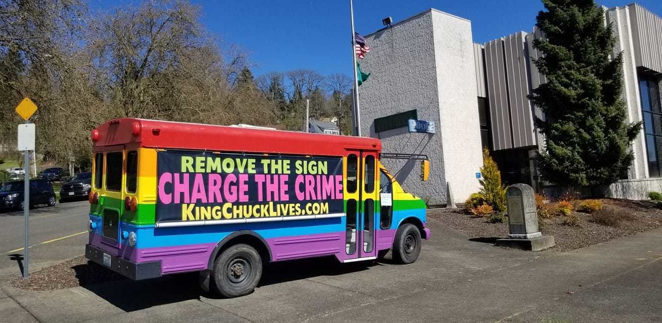 The Lollipop Guild’s bus, bearing the message “Remove the Sign, Charge the Crime, KingChuckLives.com,” is pictured parked near Chehalis City Hall shortly before it was towed on April 12.